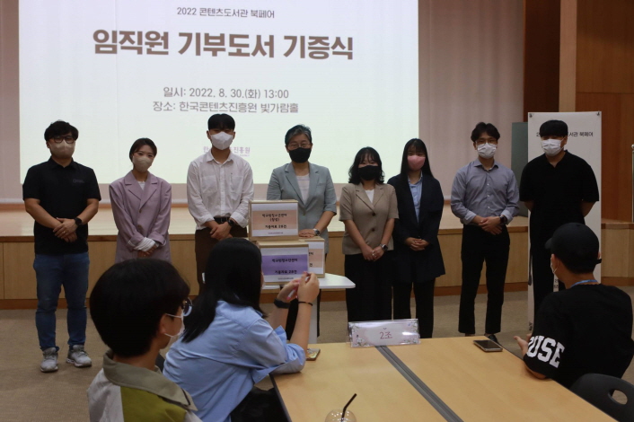 사진 2. 한국콘텐츠진흥원 임직원 기부 도서 기증식 현장 사진 한국콘텐츠진흥원 정경미 부원장(왼쪽 4번째)과 전남 소재 학교밖청소년센터 간사가 8월 30일 한국콘텐츠진흥원 임직원 기부 도서 기증식에서 기념사진을 촬영하고 있다.